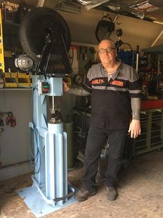 a man standing next to a machine in a garage