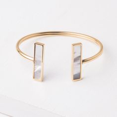 This bangle is the perfect gift to anyone you are trying to impress. Lightweight enough so it's comfortable to wear all day but with incredible mother-of-pearl detail that makes this piece a statement. Materials: 14k gold plated stainless steel and mother-of-pearl bracelet. Size: 7.5 inches Hypoallergenic; lead and cadmium free with nickel content less than 100 ppm. Box Size: Medium Chic Stainless Steel Bangle Jewelry, Elegant Brass Cuff Bracelet Gift, Chic Gold-tone Bangle As Gift, Elegant Adjustable Mother Of Pearl Bracelet, Elegant Brass Oyster Bracelet, Elegant Gold Mother Of Pearl Bracelets, Elegant Bangle Bracelet In Mother Of Pearl, Adjustable Gold Pearl Bracelet In Modern Style, Chic Adjustable Pearl Bracelet As Gift