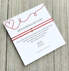 the red string of fate bracelet is attached to a card