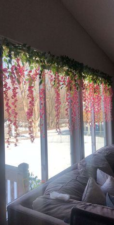 the living room is decorated with pink flowers and greenery on the windowsills