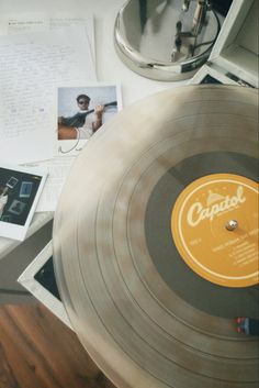 an old record player sitting on top of a table next to papers and other items