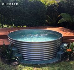 an outdoor hot tub in the middle of a yard