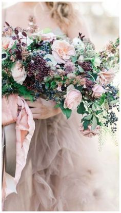 a woman holding a bouquet of flowers in her hands