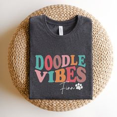 a t - shirt that says doodle vibes time on it next to a wicker basket