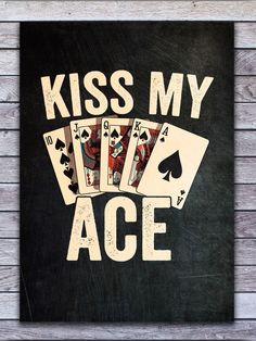 a sign that says kiss my ace with playing cards in front of it on a wooden wall