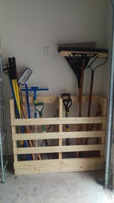 a wooden crate filled with gardening tools next to a wall