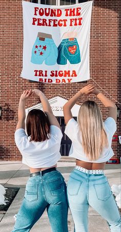 two women are dancing in front of a sign that says, found the perfect fit