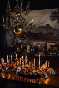 a dining room table with candles and skulls on it