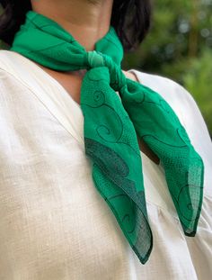 a woman wearing a white shirt and green scarf