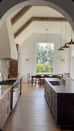 a kitchen with an archway leading to the dining room