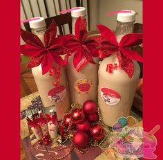 three bottles with red bows and ornaments on them