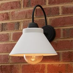 a white lamp mounted on the side of a brick wall