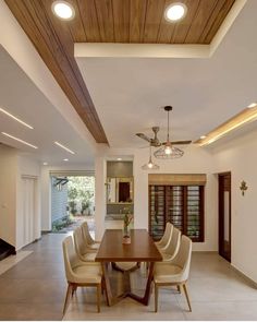 a dining room with a wooden table surrounded by beige chairs