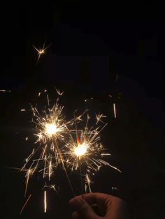 a hand holding a sparkler in the dark