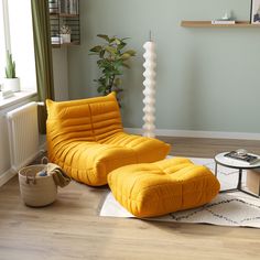 a living room with a yellow chair and ottoman on the floor in front of a window