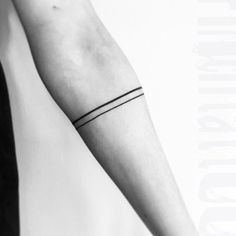 a black and white photo of a person's arm with a single line tattoo on it