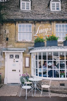 an outside cafe with tables and chairs in front of the building that says lady's