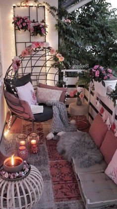 a small balcony with lots of plants and flowers on the wall, some candles lit up