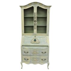 an old dresser with glass doors and drawers on it's front legs, painted in white