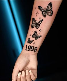 a woman's arm with butterflies on it and the numbers 1994 written in black ink