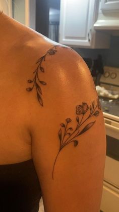 a woman's shoulder with flowers on it and an arrow in the middle is shown