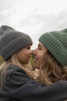 two women are hugging each other outside