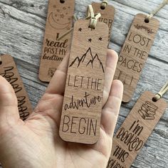 someone is holding some wooden tags with words on them