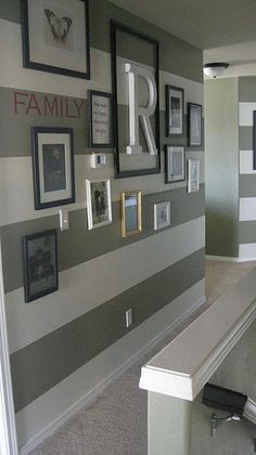 a hallway with striped walls and pictures on the wall