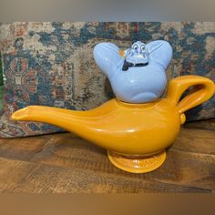 a yellow teapot sitting on top of a wooden table