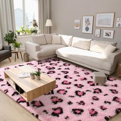 a living room with pink and black rugs on the floor, two couches and a coffee table