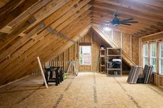 an attic with wooden walls and exposed ceiling