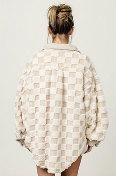 a woman with her back turned to the camera, wearing a white checkered jacket