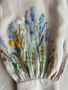 embroidered flowers are on the back of a white shirt