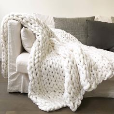 a white blanket sitting on top of a couch