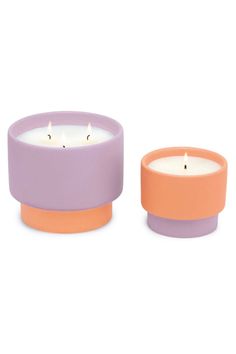 two candles sitting next to each other on a white surface