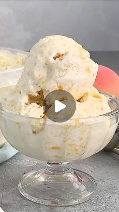 a bowl filled with ice cream sitting on top of a table next to an apple