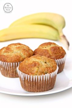 three muffins on a white plate with a banana in the backgroun