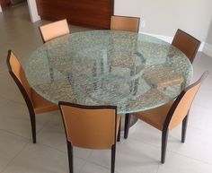 a glass table with chairs around it in the middle of a floored room area