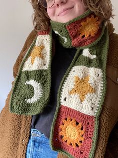 the woman is wearing a scarf with crocheted animals on it, and she has her eyes closed