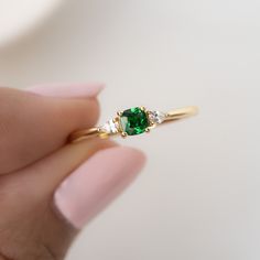 Sweet, simple, and dainty emerald ring. Perfect for a minimalist look, or for stacking. It adds a fun pop of color to your look! Featuring a cushion cut stone with pear stones adorning both sides - making this a delicate and beautiful ring! Emerald rings are said to represent luck, love, peace, and hope. - - - D E T A I L S - - - * Made of 925 Sterling Silver * Available in 14k Gold or Rhodium Plating * We use a THICK 14k Gold plating - for a piece that will last you years to come!  * VERY HIGH QUALITY  * Made of the highest grade of cubic zirconia stones for an authentic look * Available in sizes 4-10 * Ring Height: 3.6mm * Also available in Aquamarine, Pink & Yellow  Pink Ring https://www.etsy.com/listing/1571015482/pink-diamond-ring-morganite-ring?click_key=bc6ca9b0cb68a4d2a66c864f3eb50 Pink Diamond Ring, Yellow Rings, Dainty Gold Rings, Zierlicher Ring, Cushion Ring, Ringe Gold, Ring Emerald, Morganite Ring