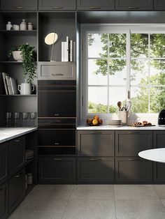 a kitchen with black cabinets and white counter tops, along with a large window that looks out onto the trees outside