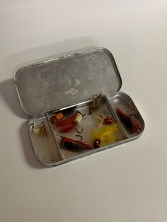 two tins filled with different types of fishing flies