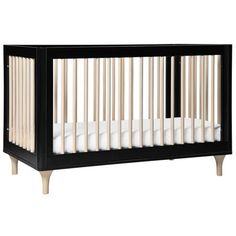 a baby crib that is black and white with wood trim on the bottom part