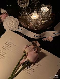 an open book with flowers and candles on it