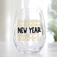 a wine glass with the words happy new year written on it in black and gold