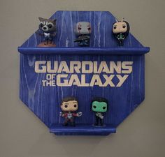 three pop - up figurines sitting on top of a blue shelf that says, guardianss of the galaxy