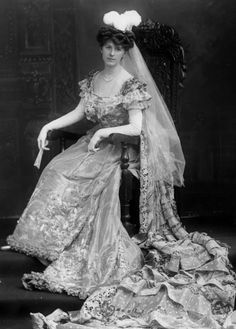 an old black and white photo of a woman in a wedding dress sitting on a chair