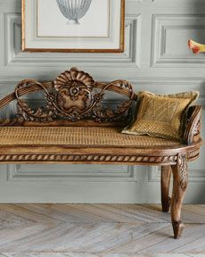 a wooden bench sitting in front of a wall with paintings on it's sides