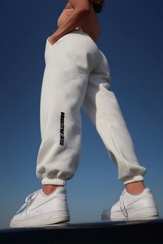 "Our white \"SEASON\" joggers are high on quality and low on well...nothing! Super soft, comfy and stylish and made of 100% cotton. Can easily be styled up or down, and will both look and feel amazing paired with anything. We're thinking cosy winter days and long summer evenings. Maybe the best quality joggers you've ever had?  - Colour: White - Drawstring waist - Cuffed ankles - Can be worn full length or rolled into cropped - Super soft fleece lining - Pockets - Elasticated waistband with draw Athleisure Cotton Bottoms With Logo Print, Cotton Sportswear Bottoms With Logo Print, Cotton Athleisure Bottoms With Logo Print, Casual Jogging Bottoms With Logo Print, Spring Letter Print Joggers For Loungewear, Casual Sweatpants With Logo Print For Loungewear, Casual Logo Print Sweatpants For Loungewear, Casual Relaxed Fit Sweatpants With Logo Print, Athleisure Joggers With Logo Print In Relaxed Fit