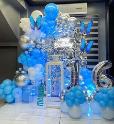 blue and white balloons are on display in a room